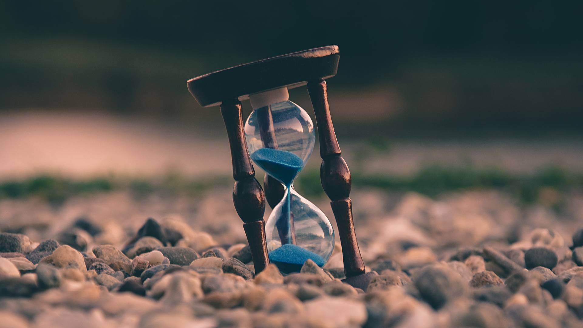 Sanduhr die auf groben Kieselsteinen steht - Quelle: Aron Visuals via unsplash.com